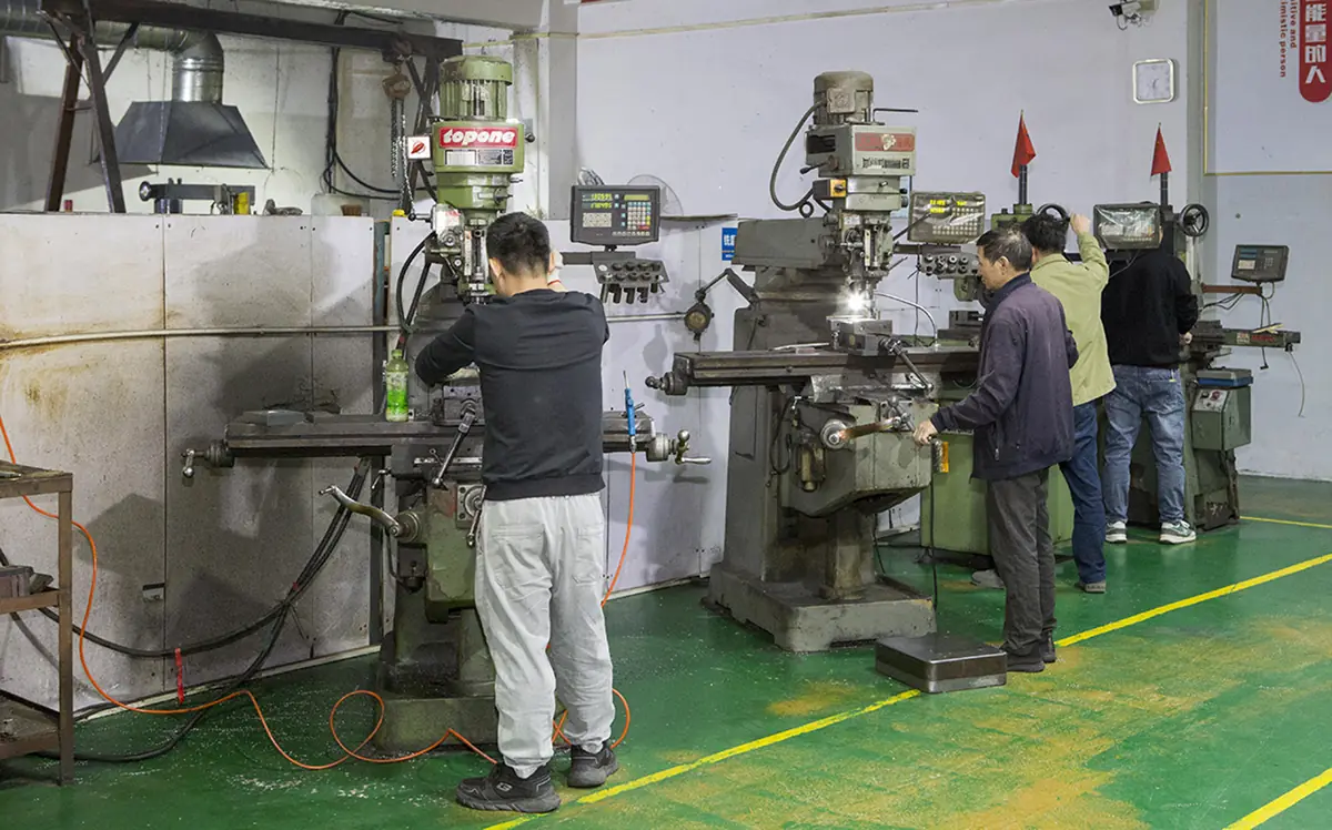 Factory machining workshop with operators preparing molds and metal components